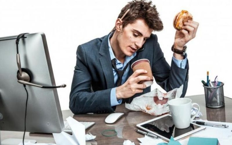 Homem comendo no escritório
